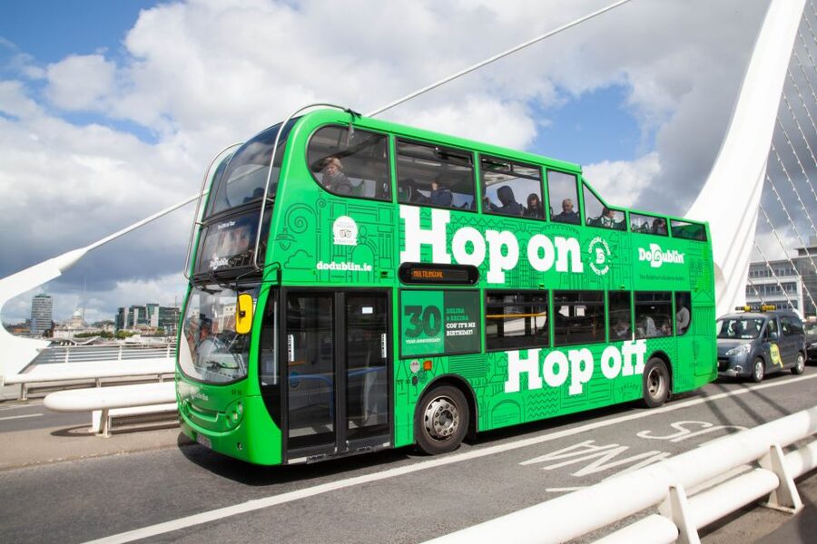 Dublin: Airport Transfer and Hop-On Hop-Off Bus Ticket - Live guides, singing, and recorded commentary